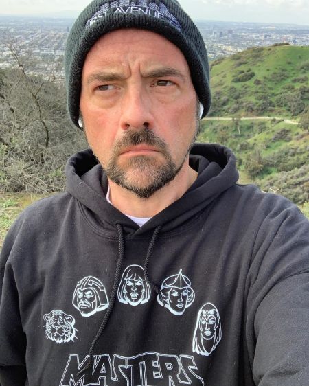 Filmmaker Kevin Smith in a blue hoodie poses for a picture.
